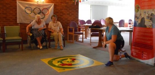 Older people playing bean bag target game
