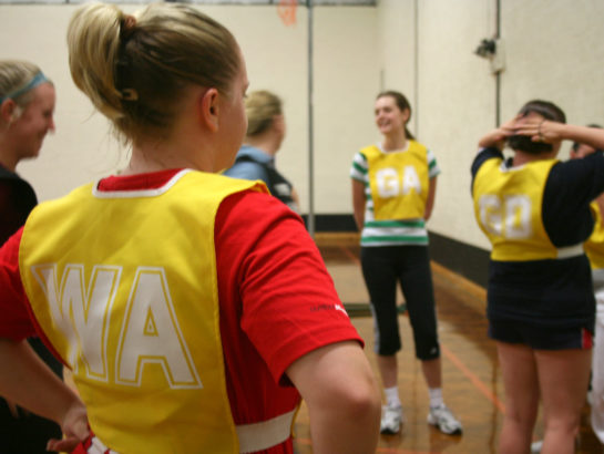 Women stood in Netball bibs