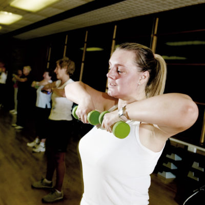 Women lifting barbells to chin