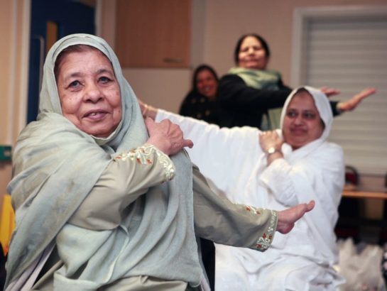 Asian women participating in a seated exercise class