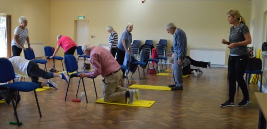 Kneeling leg stretch at Falls class