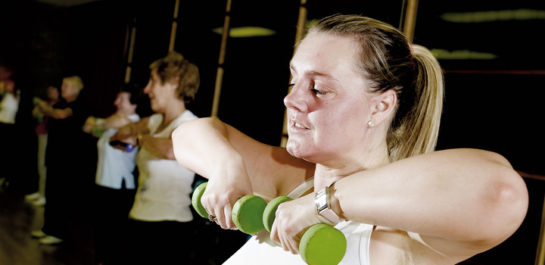 Women lifting barbells to chin