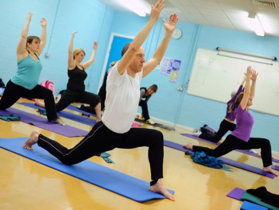 Group of adults stretching in a Yoga class