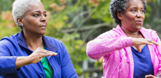 Two women following tai chi movements