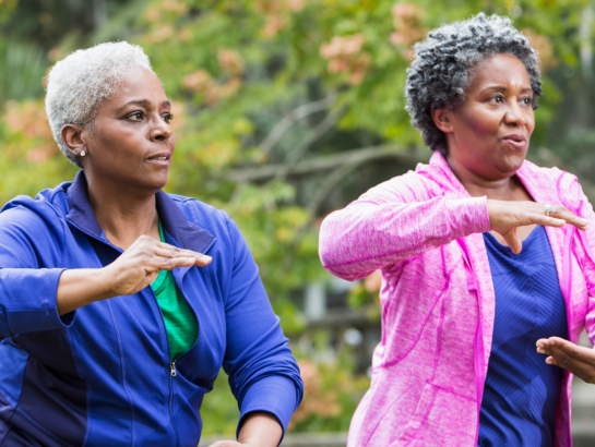 Two women following tai chi movements